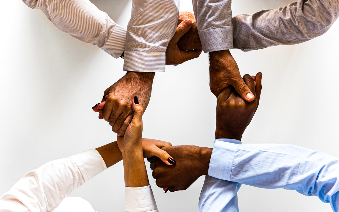 people holding hands in a circular path