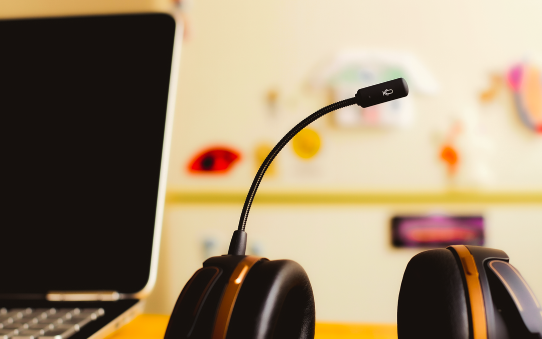 Microphone, headset and laptop on a table